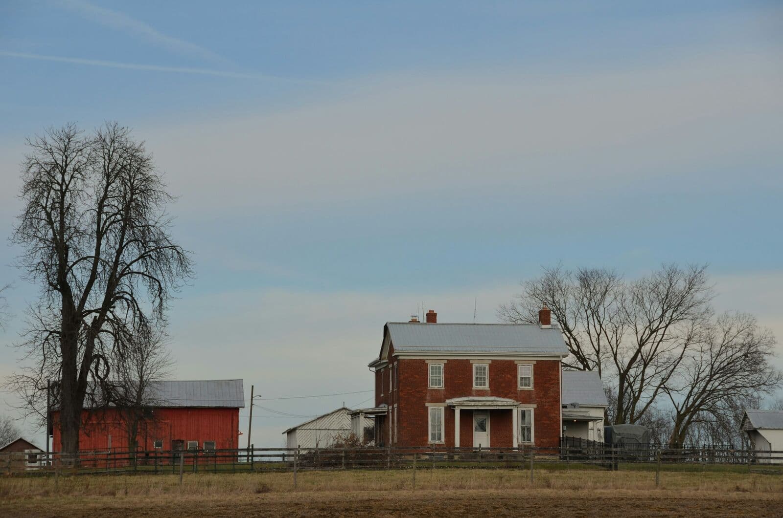 Red-brick farmhouse and red barn in open Virginia farmland